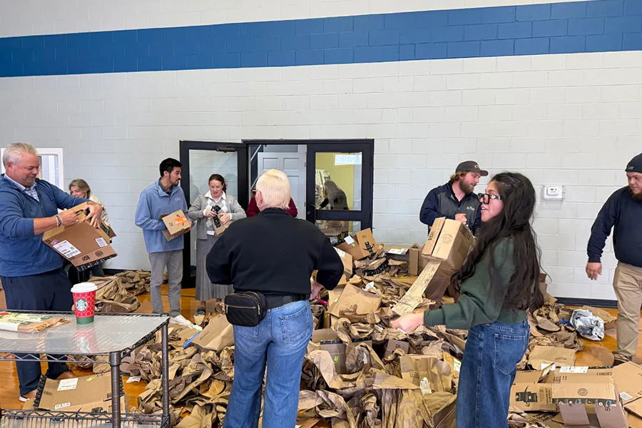 group of JCH employees doing volunteer work with breaking down boxes